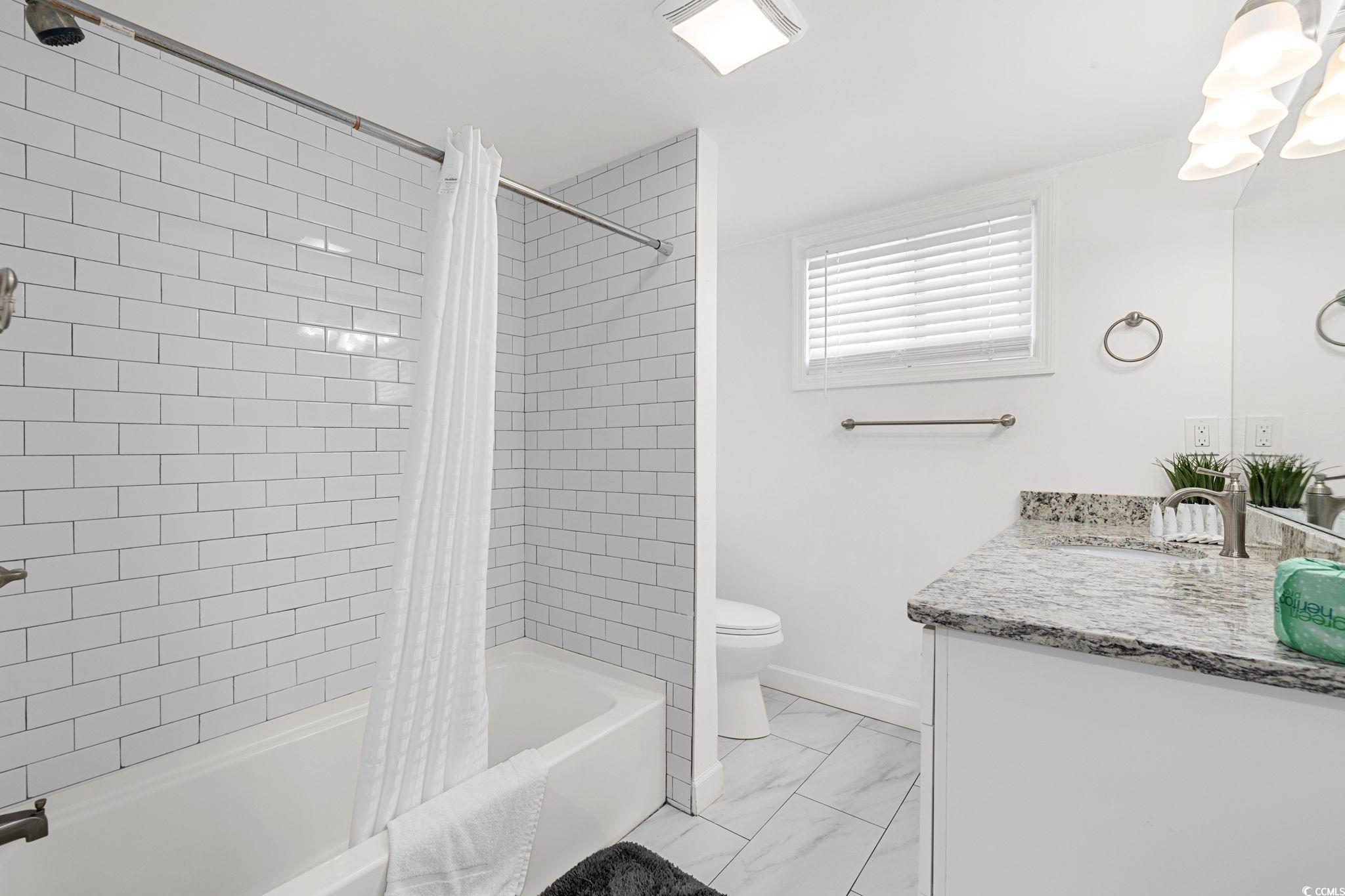 409 17th Avenue North, Unit 1 Myrtle Beach, SC 29577 - Photo 22 of 26 Full bath with shower / bath combo, vanity, and light marble finish flooring