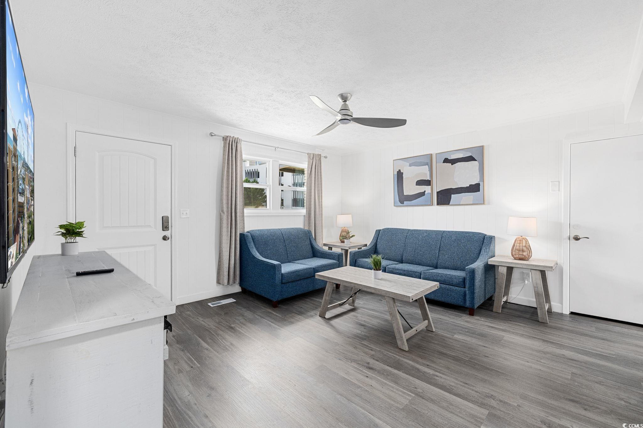 409 17th Avenue North, Unit 1 Myrtle Beach, SC 29577 - Photo 4 of 26 Living area with a textured ceiling, a ceiling fan, and dark wood finished floors