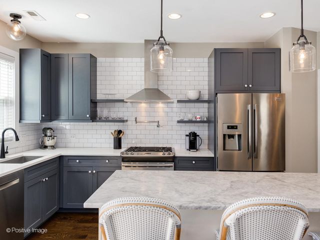 a kitchen with stainless steel appliances granite countertop a sink refrigerator and microwave