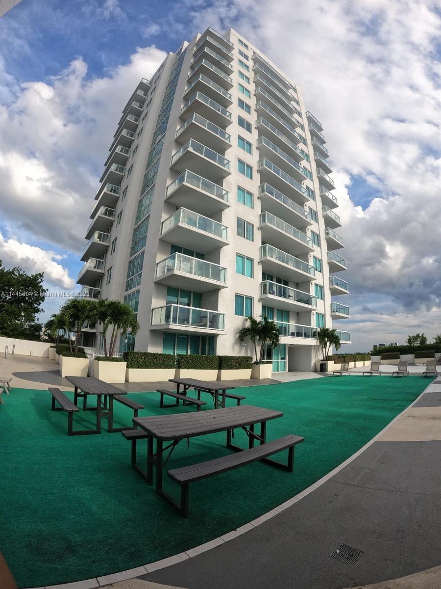 Grapeland Heights Miami, FL 33125 - Photo 29 of 36 a building view with a bench sitting in middle of garden