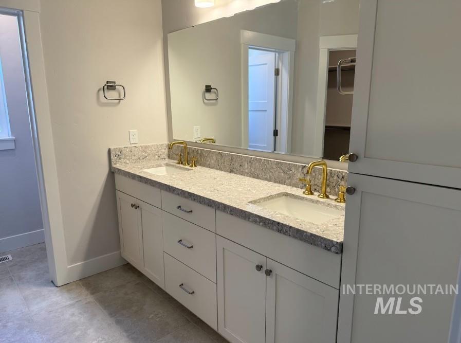 665 West Wrangler Street Meridian, ID 83646 - Photo 8 of 18 Dual vanity featuring white shaker-style cabinetry, a speckled countertop, and gold-finish faucets