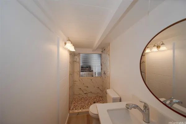 a bathroom with a sink and mirror with toilet