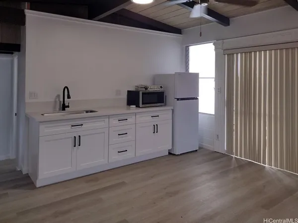 a kitchen with cabinets wooden floor and a window