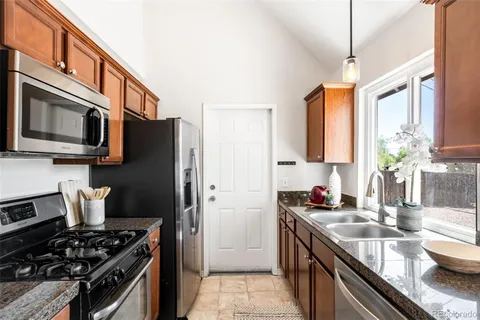 a kitchen with stainless steel appliances granite countertop a stove a sink dishwasher a refrigerator and a microwave