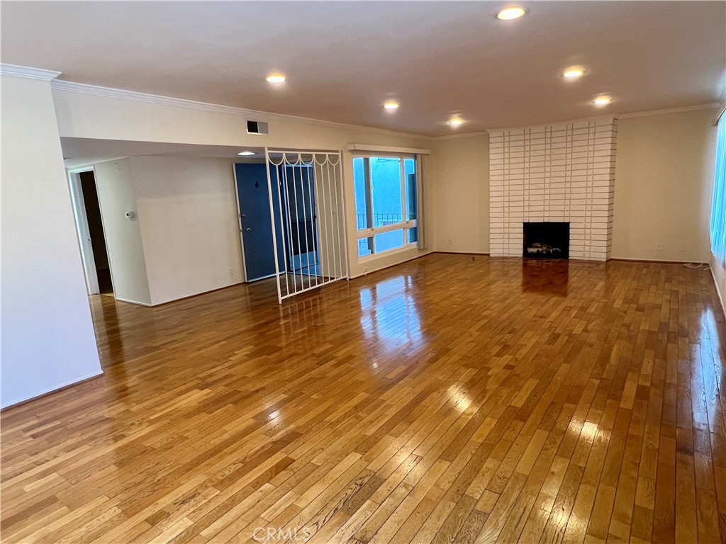 a view of empty room with wooden floor and fireplace