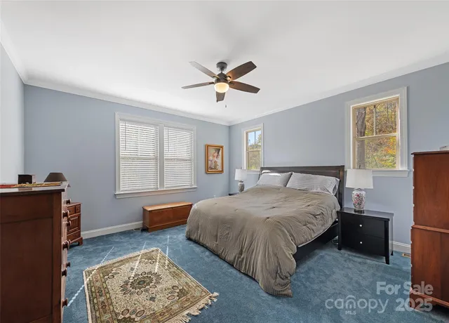 a spacious bedroom with a bed and a chandelier