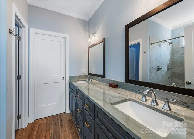 a bathroom with a granite countertop double vanity sink and mirror
