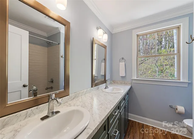a bathroom with a granite countertop sink a large mirror a and a window