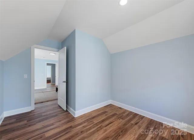a view of a room with wooden floor and a bathroom