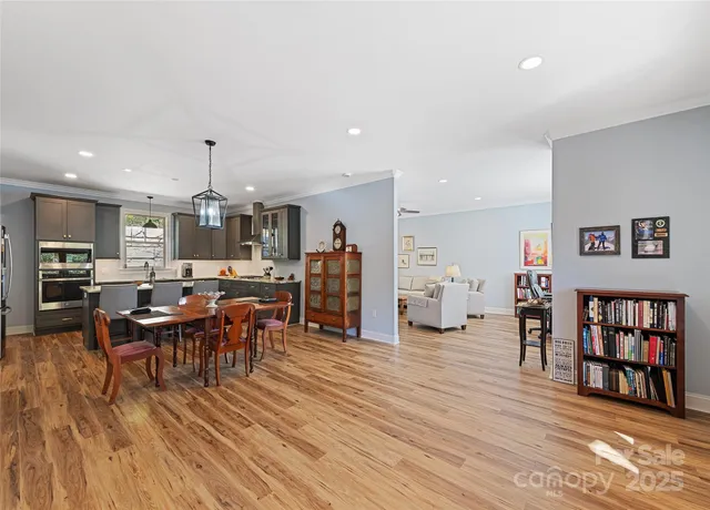 a living room with furniture and a dining table with wooden floor