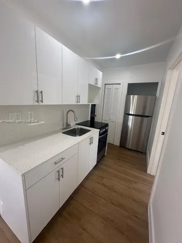 a kitchen with a sink and refrigerator