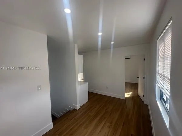 a view of a room with wooden floor and a window