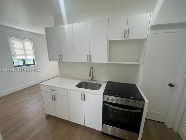 a kitchen with a sink stove and cabinets