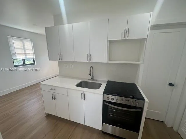 a kitchen with a sink stove and cabinets