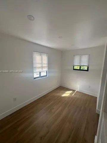 a view of a room with wooden floor and window