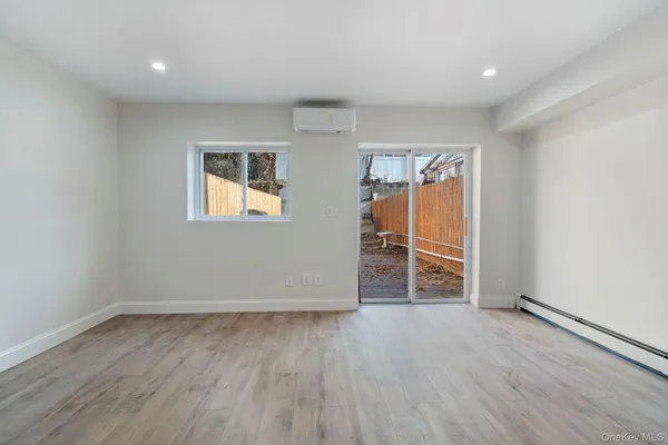 an empty room with wooden floor and window