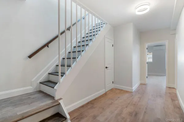 a view of entryway and hall with wooden floor