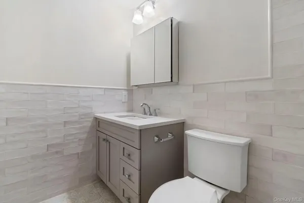 a bathroom with a granite countertop toilet sink and mirror