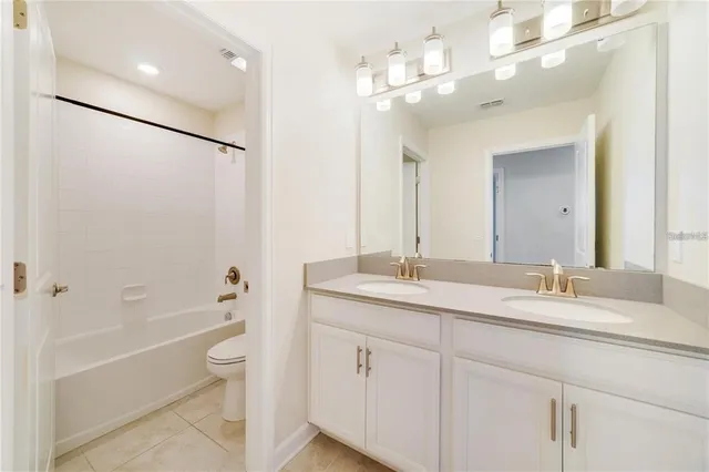 a bathroom with a granite countertop sink mirror toilet and bathtub
