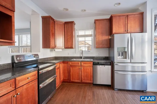 a kitchen with stainless steel appliances granite countertop a refrigerator sink and cabinets