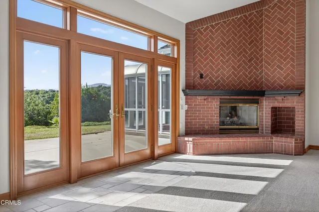an empty room with windows and ceiling fan