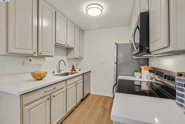 a kitchen with granite countertop a sink a stove and cabinets