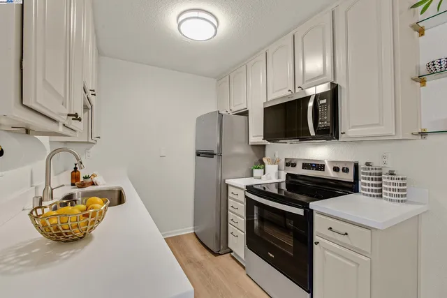 a kitchen with stainless steel appliances granite countertop a sink a stove and cabinets
