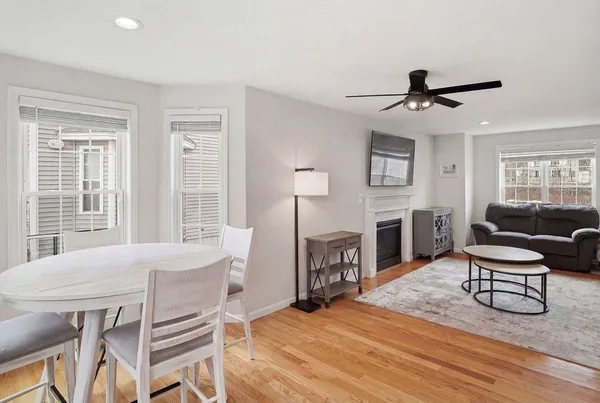 a view of a livingroom with furniture a fireplace a window and wooden floor