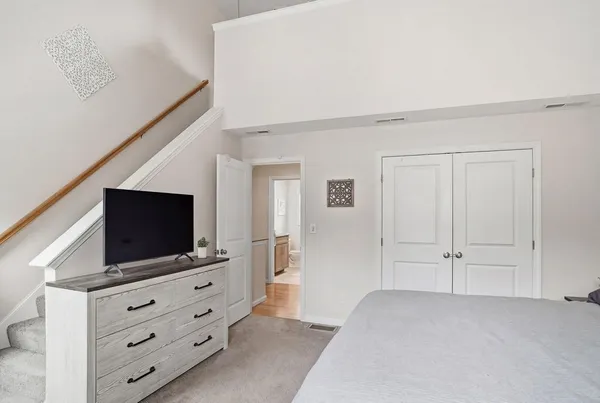 a room with flat screen tv on dresser and a flat screen tv