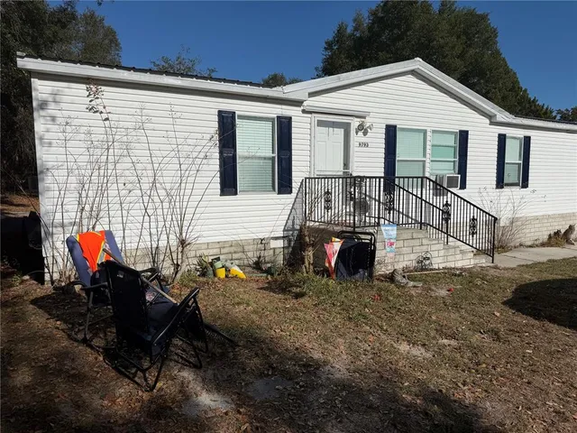 a view of a house with a patio and a yard