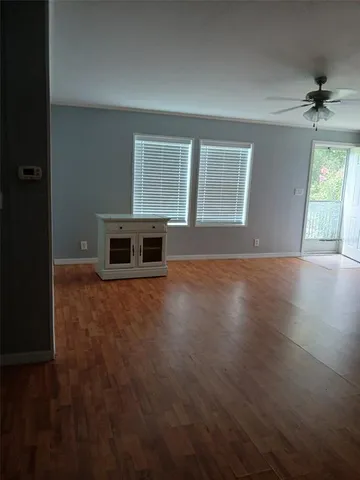 an empty room with windows and cabinet