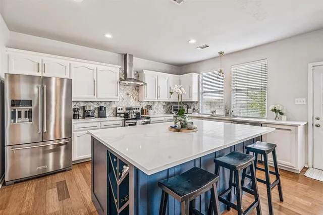 a kitchen with a table chairs refrigerator and cabinets