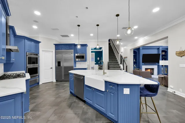 a utility room with stainless steel appliances wooden floor and window