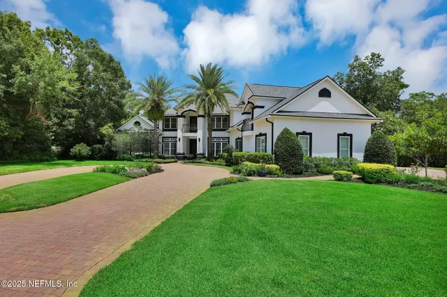 a front view of a house with a yard and trees