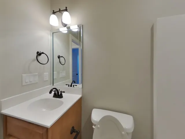a bathroom with a sink a light fixture and a toilet