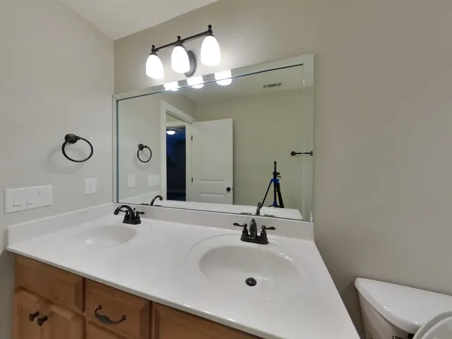 a bathroom with a sink a light fixture and a mirror