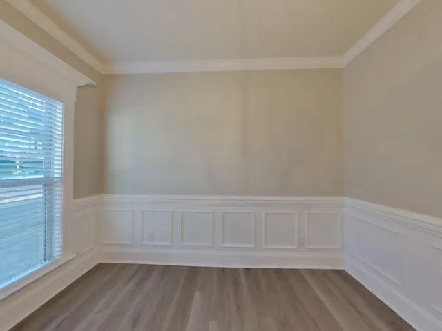a view of an empty room with wooden floor