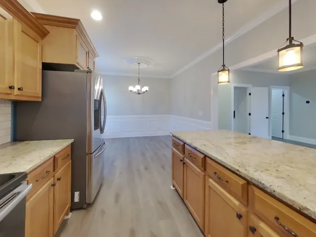 a kitchen with a stove and a wooden floor