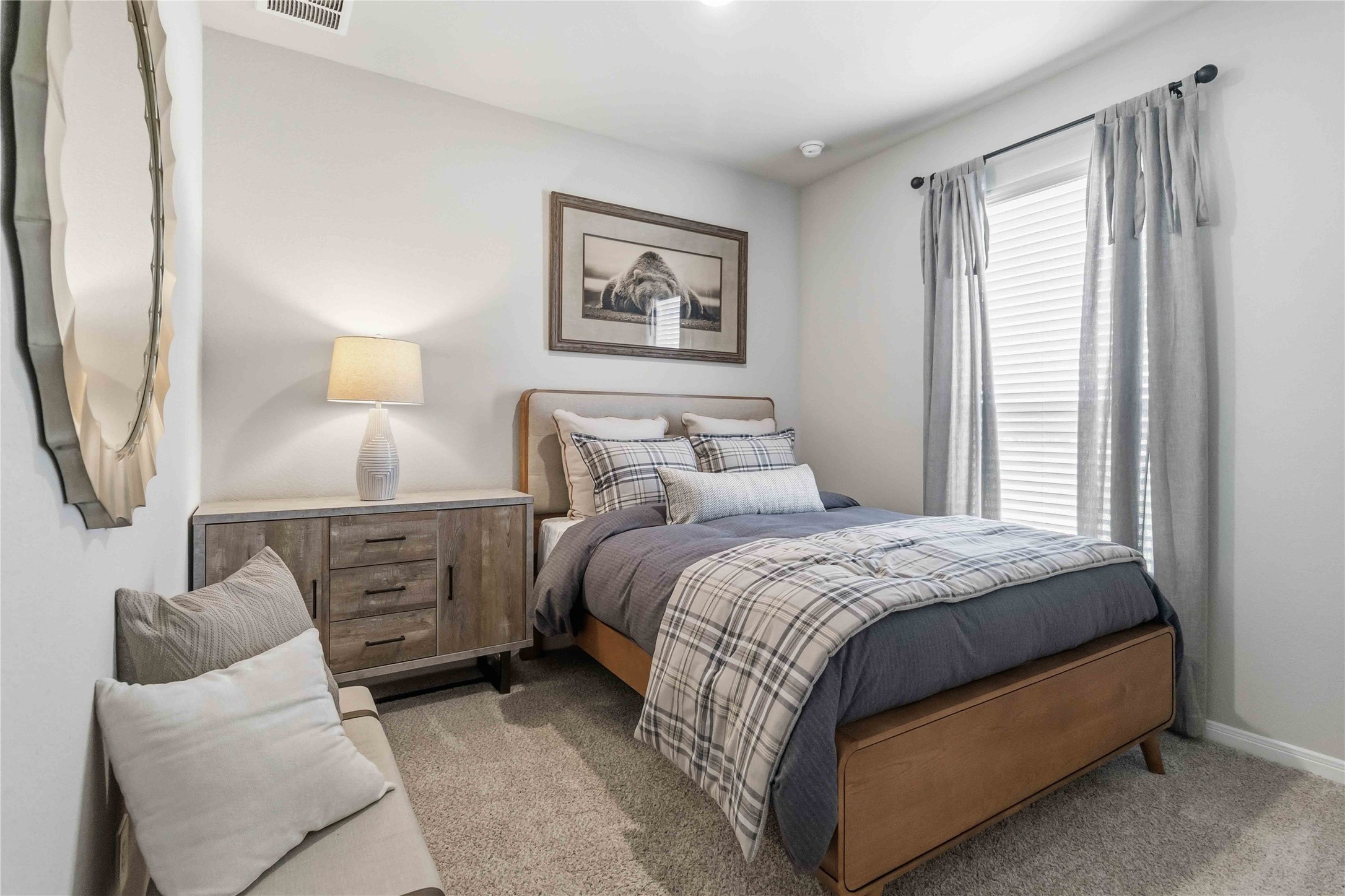 Soft carpeting underfoot and a large window create a comfortable, inviting atmosphere.