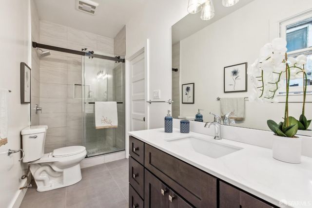 a bathroom with a sink toilet double vanity and shower