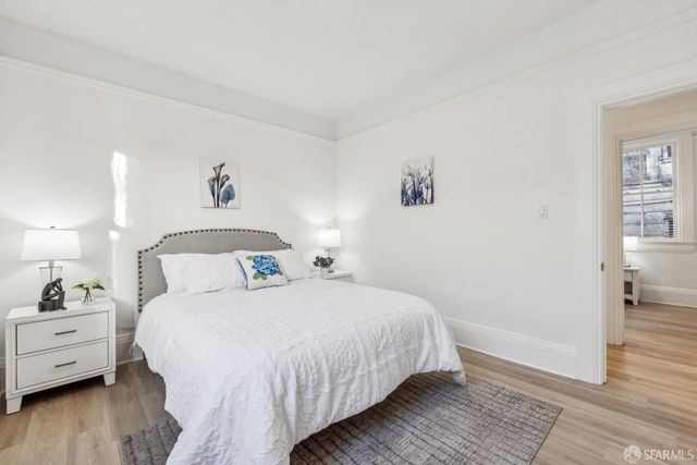 a bedroom with a bed and wooden floor