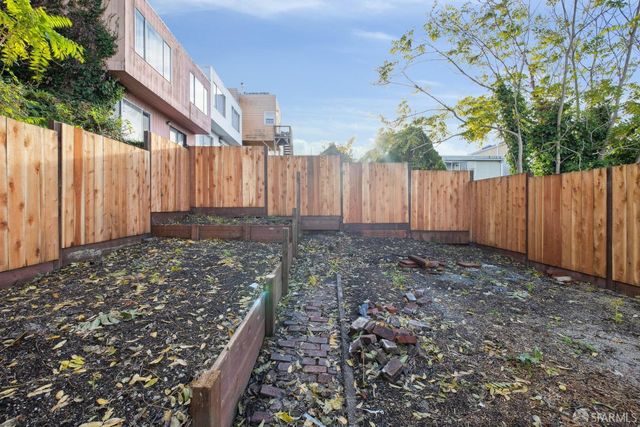 a view of a yard with wooden fence
