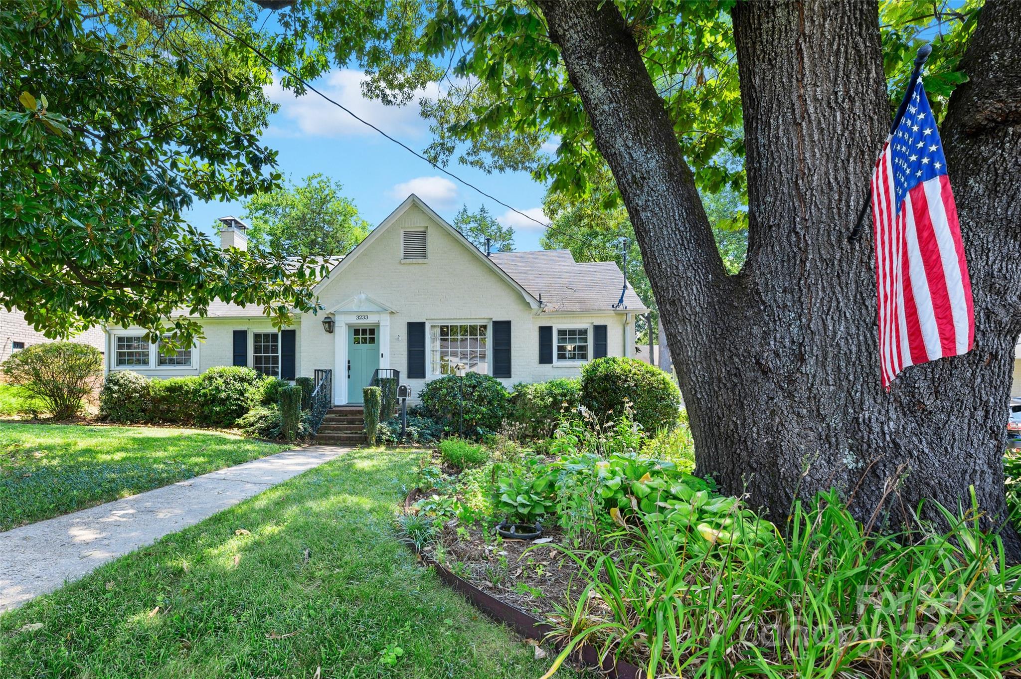 3233 Pinehurst Place Charlotte, NC 28209 - Photo 1 of 39 a aerial view of a house with a yard and potted plants