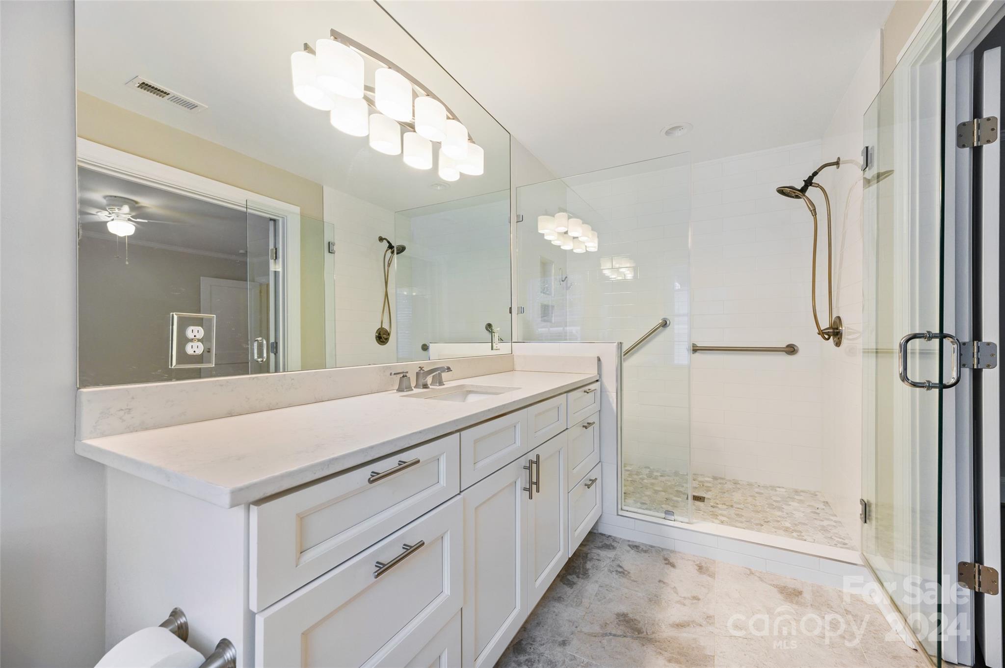 3233 Pinehurst Place Charlotte, NC 28209 - Photo 21 of 39 a spacious bathroom with a shower sink and mirror