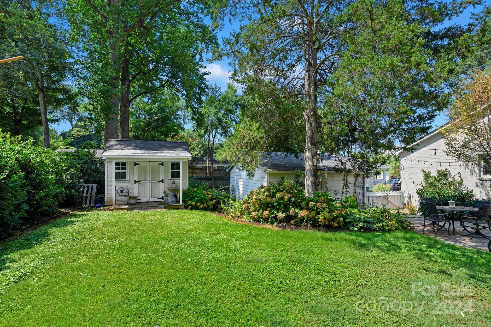 3233 Pinehurst Place Charlotte, NC 28209 - Photo 25 of 39 a view of a house with a big yard and potted plants and large trees