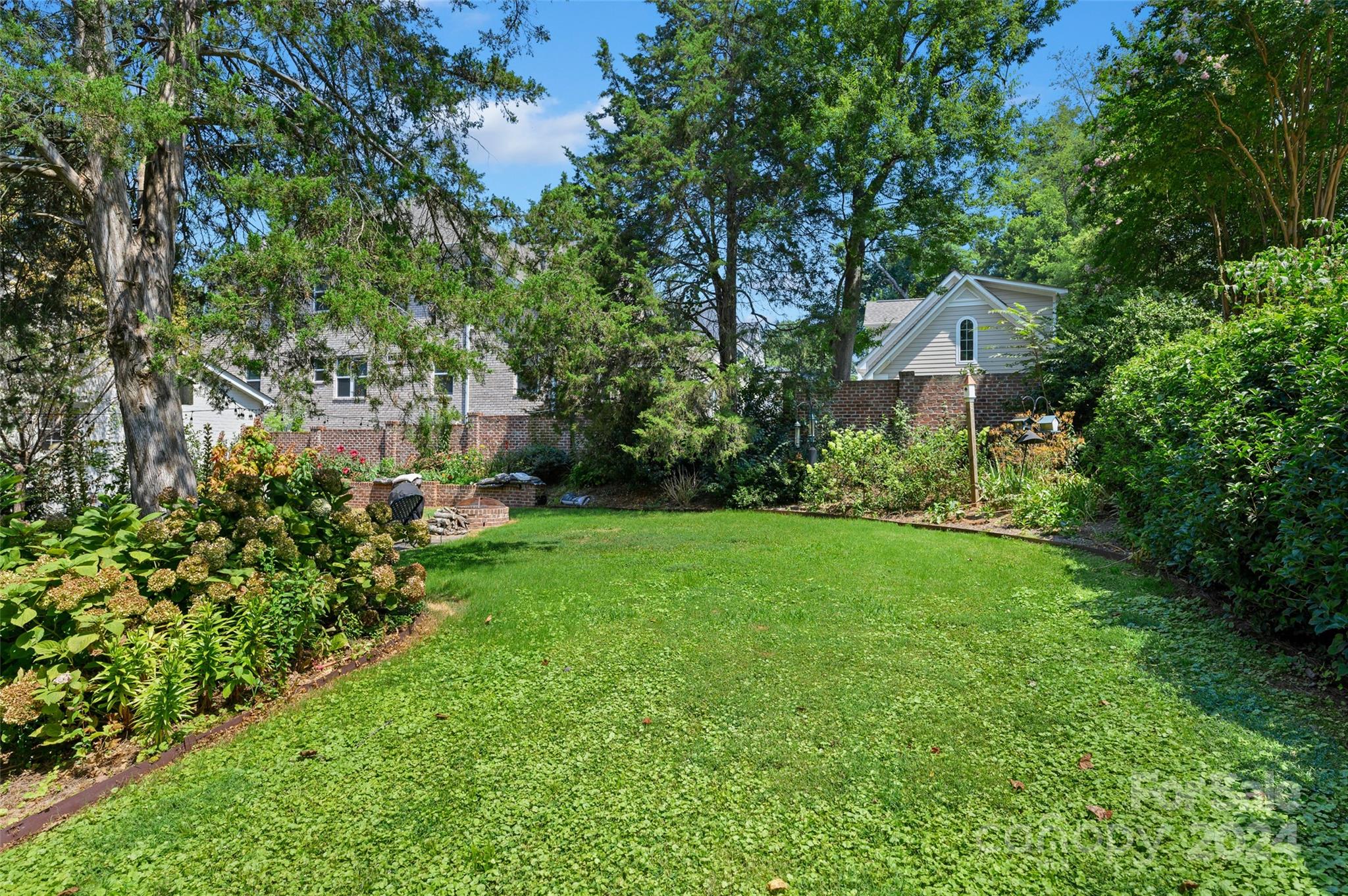 3233 Pinehurst Place Charlotte, NC 28209 - Photo 27 of 39 a view of a garden with plants and large trees