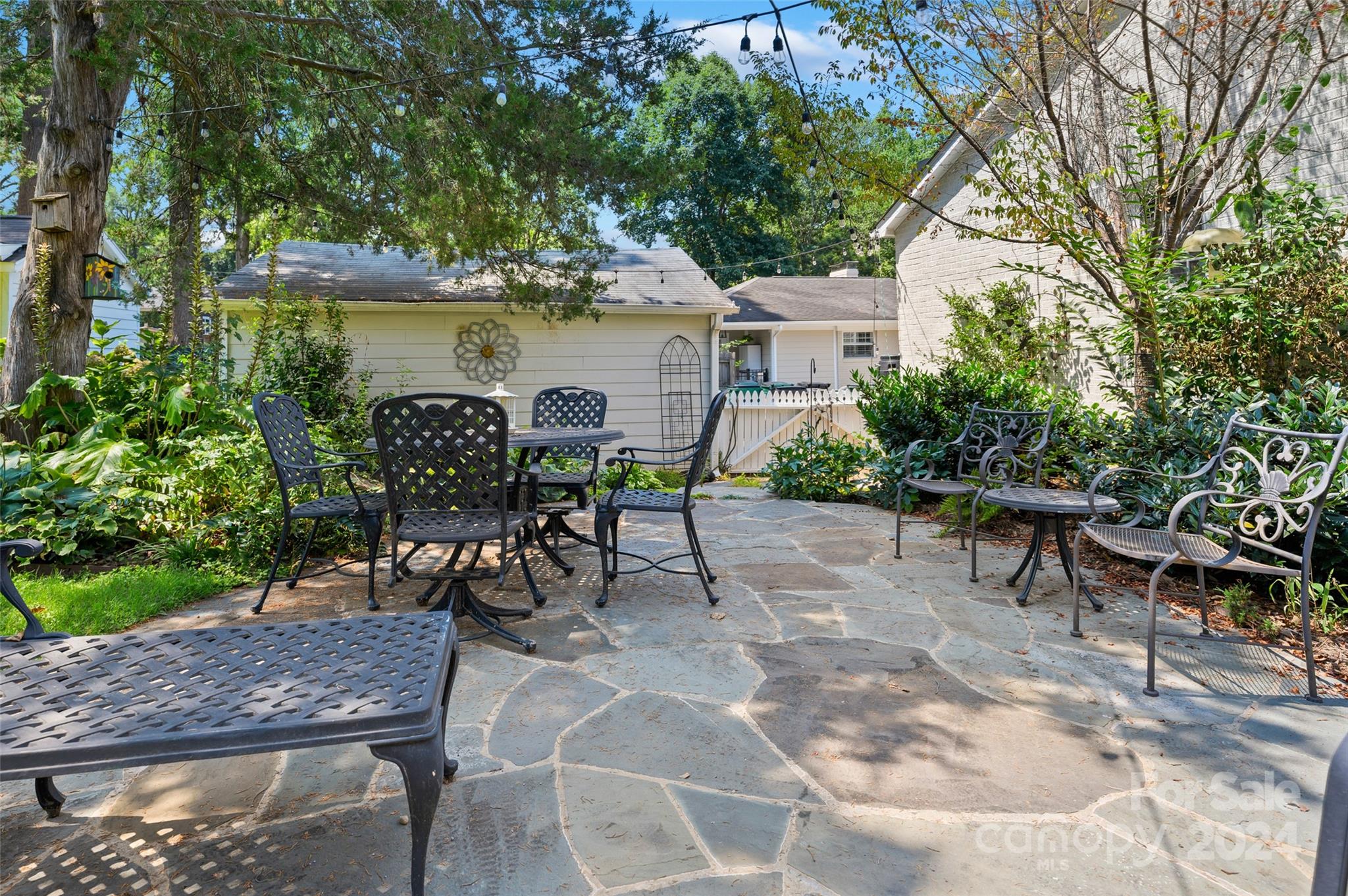 3233 Pinehurst Place Charlotte, NC 28209 - Photo 30 of 39 a view of a patio with table and chairs and potted plants with large tree
