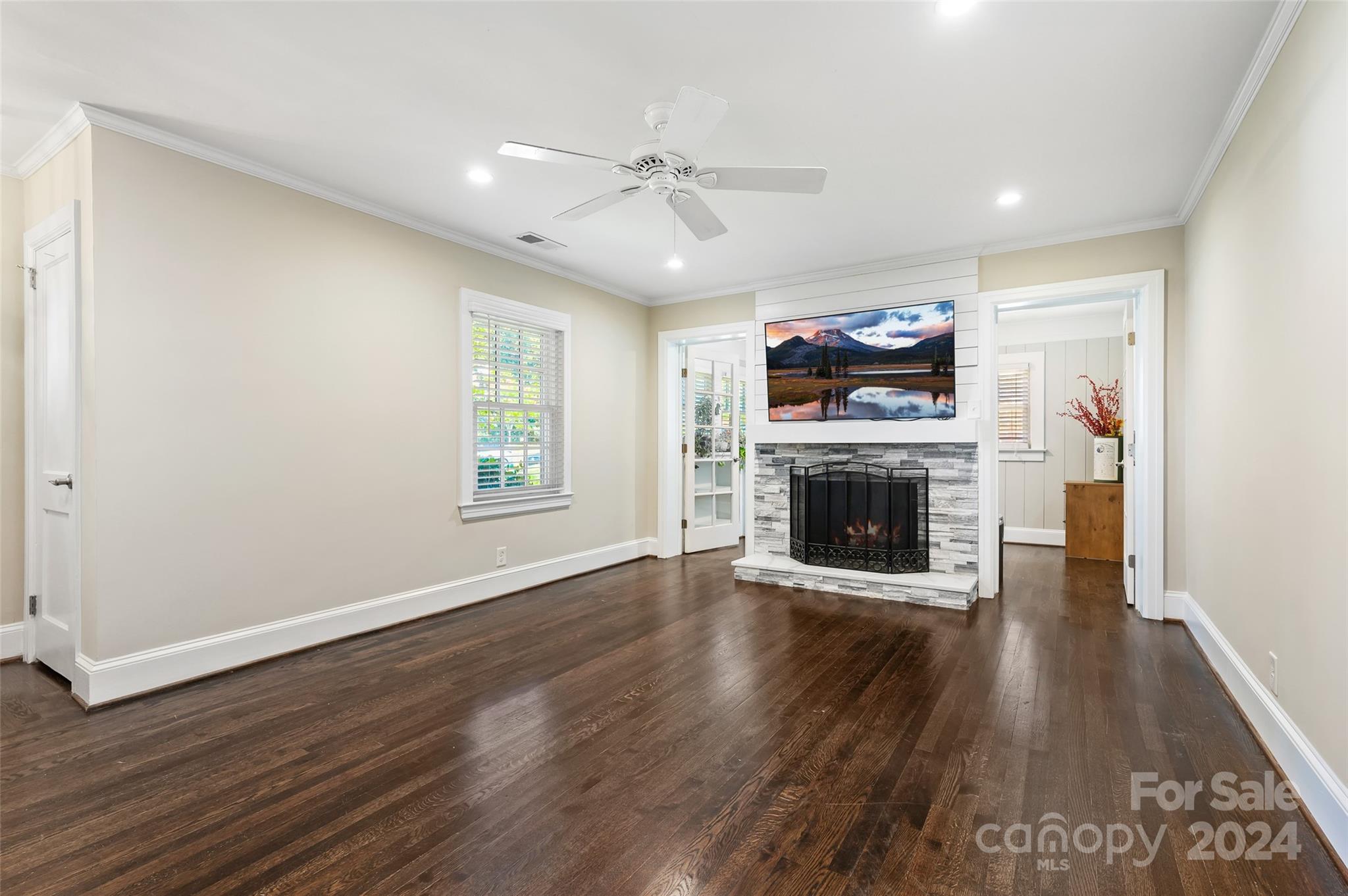 3233 Pinehurst Place Charlotte, NC 28209 - Photo 4 of 39 an empty room with wooden floor fireplace and windows