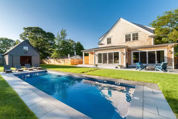 a view of a house with swimming pool and sitting area
