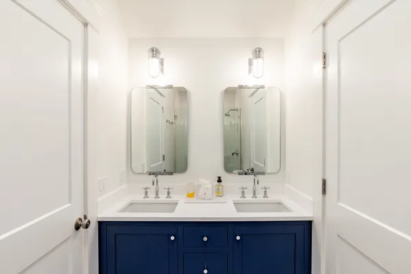 a bathroom with double vanity sinks and a mirror